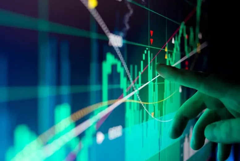 Mão interagindo com gráficos de mercado em fundo escuro com indicadores e barras verdes e vermelhas, simulando análise de ações e tendências financeiras em tempo real.